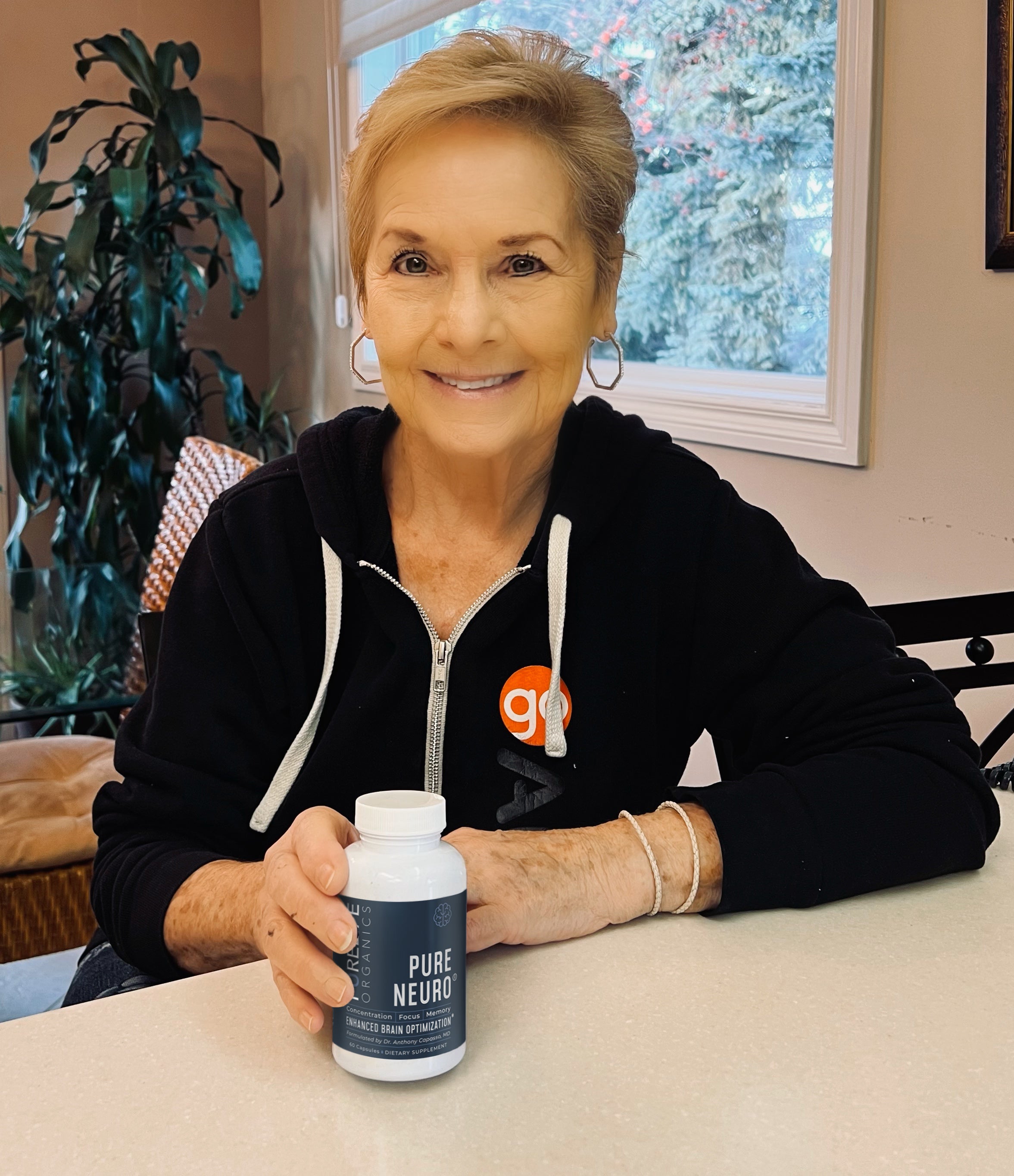 Person holding Pure Neuro brain supplement bottle by PureLife Organics – daily nootropic support for memory, clarity, and focus in a modern lifestyle setting